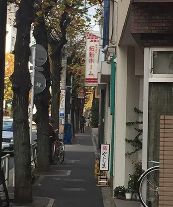 並木通りの入口。右手に不動産『拓新ホーム』の看板が見える